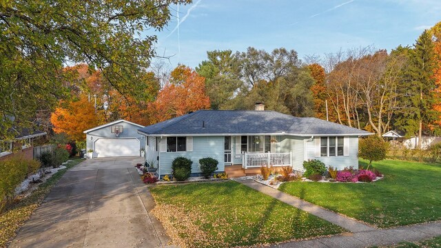 409 Louise Ave, Dowagiac, MI 49047 - ranch-style home featuring covered porch, driveway, a front yard, an outbuilding, and a garage