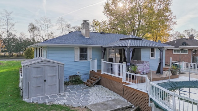 409 Louise Ave, Dowagiac, MI 49047 - rear view of property with roof with shingles, a chimney, a gazebo, a storage shed, and an outbuilding
