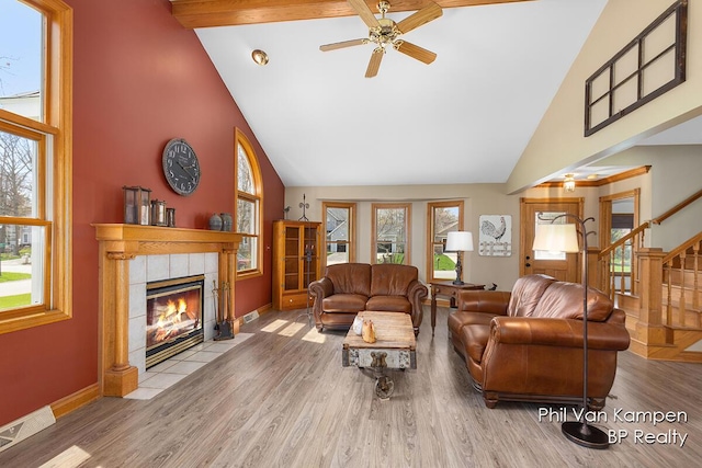 living room with visible vents, a fireplace, wood finished floors, high vaulted ceiling, and a wealth of natural light