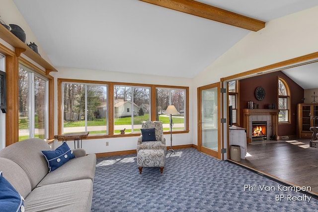carpeted living area with a tiled fireplace, baseboards, lofted ceiling with beams, and wood finished floors