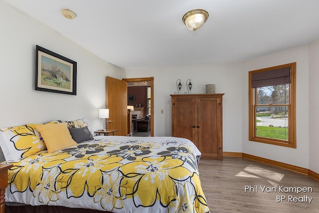 bedroom with baseboards and wood finished floors