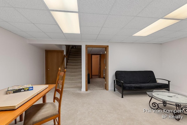 sitting room with carpet floors, a drop ceiling, and stairway