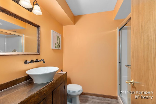 full bath featuring vanity, a stall shower, toilet, and wood finished floors