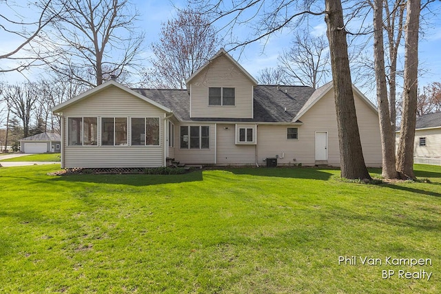 rear view of house featuring a sunroom, central AC unit, and a lawn