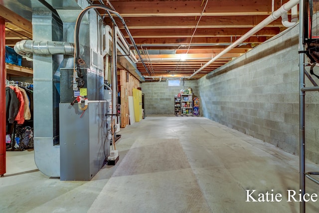 unfinished basement with concrete block wall and heating unit