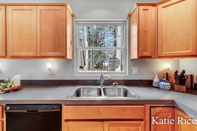 kitchen with light brown cabinets, dark countertops, a sink, and dishwasher