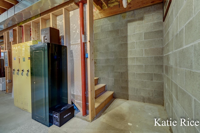 unfinished below grade area featuring concrete block wall and stairs