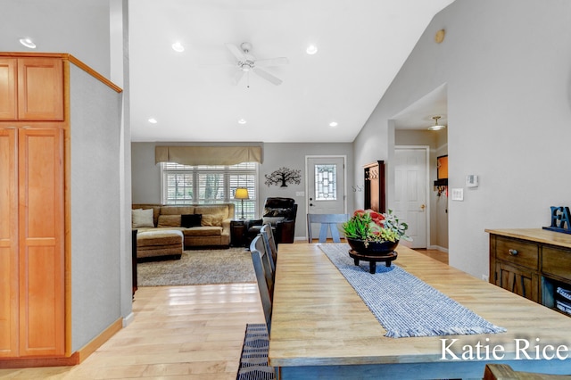 dining room featuring a ceiling fan, baseboards, lofted ceiling, and light wood-style floors