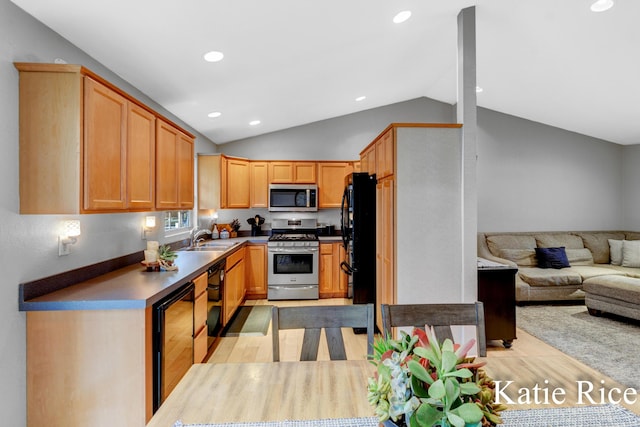 kitchen with a sink, open floor plan, lofted ceiling, light wood-type flooring, and black appliances