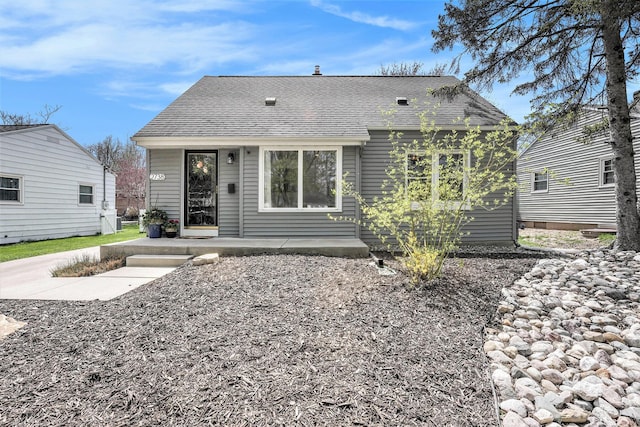 rear view of property featuring roof with shingles