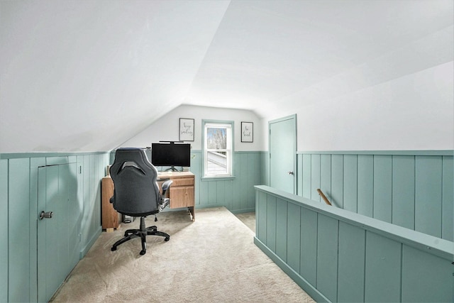 carpeted office with wainscoting and lofted ceiling