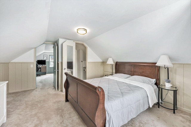 bedroom featuring carpet floors, wainscoting, and lofted ceiling
