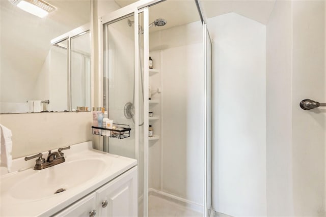 bathroom featuring vanity, a stall shower, and lofted ceiling