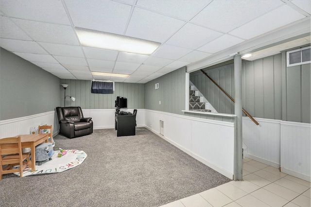 interior space featuring carpet floors, visible vents, wainscoting, and a paneled ceiling