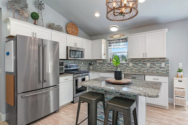 8308 E G Ave, Kalamazoo, MI 49048 - kitchen featuring backsplash, stainless steel appliances, white cabinetry, and lofted ceiling