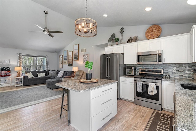 8308 E G Ave, Kalamazoo, MI 49048 - kitchen with visible vents, light wood-type flooring, ceiling fan with notable chandelier, and stainless steel appliances
