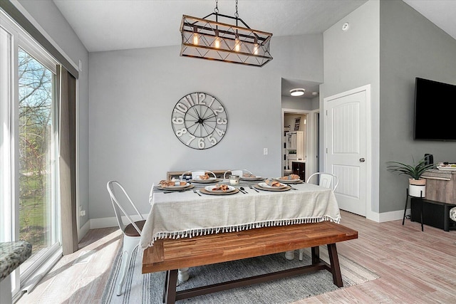 8308 E G Ave, Kalamazoo, MI 49048 - dining area with light wood-style floors, baseboards, and vaulted ceiling