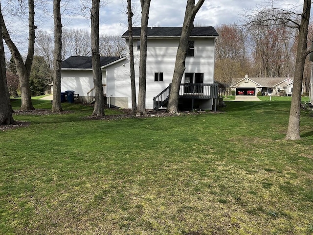 rear view of house featuring a yard and a deck