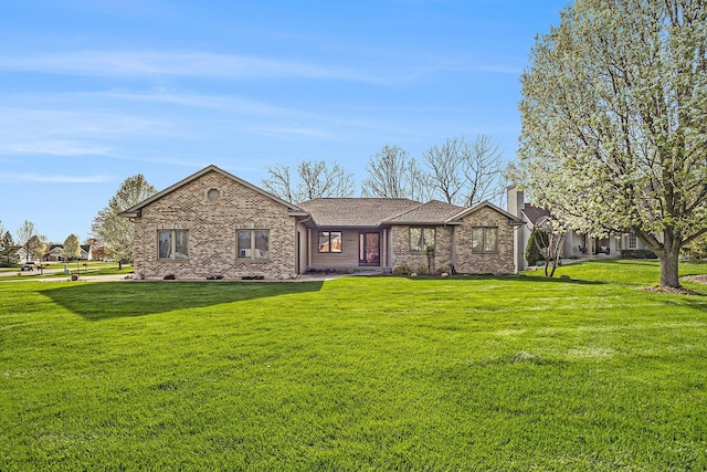 single story home with brick siding, a shingled roof, a chimney, and a front yard