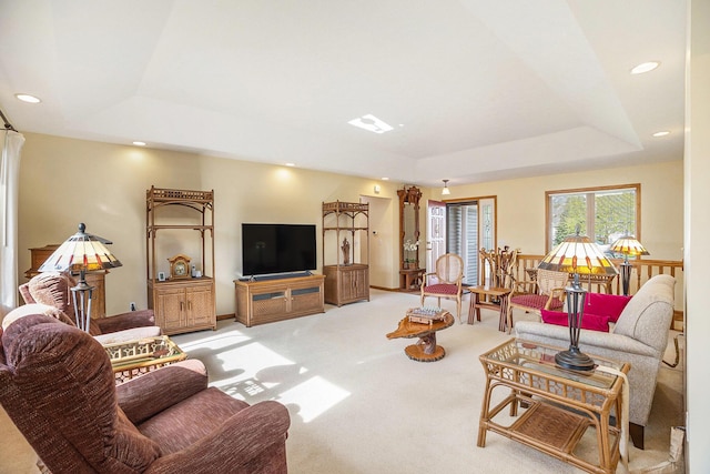 living area featuring recessed lighting, carpet, and a raised ceiling