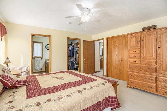 bedroom with connected bathroom, ceiling fan, and light colored carpet