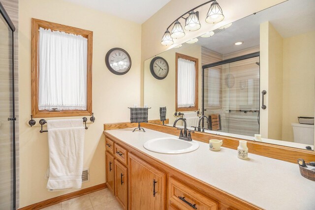 bathroom with visible vents, vanity, toilet, tile patterned floors, and a shower stall