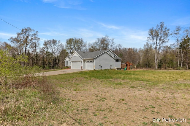 view of home's exterior featuring a lawn, an attached garage, concrete driveway, and a playground