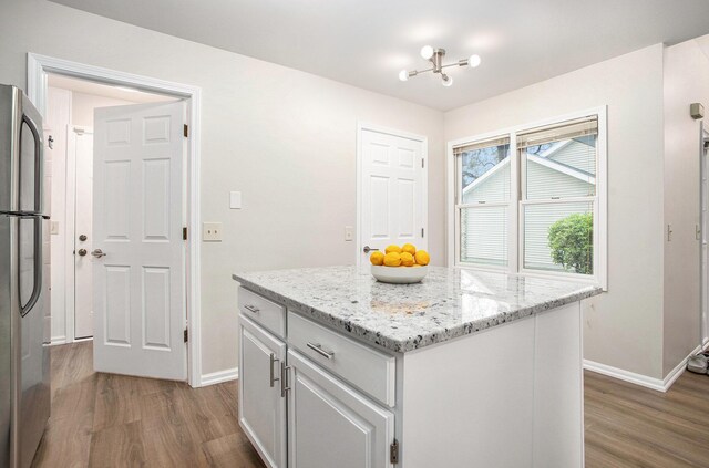 kitchen featuring stainless steel fridge, dark wood-style flooring, and baseboards