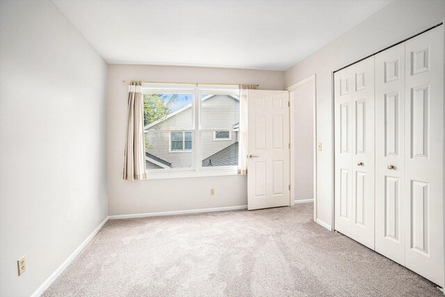 unfurnished bedroom with a closet, baseboards, and carpet flooring