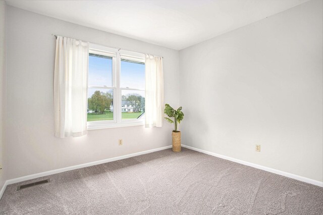 unfurnished room with carpet floors, baseboards, and visible vents