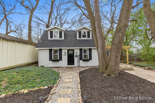 view of front of property featuring roof with shingles and fence