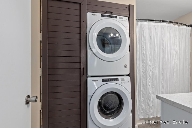 clothes washing area with stacked washer / drying machine and laundry area