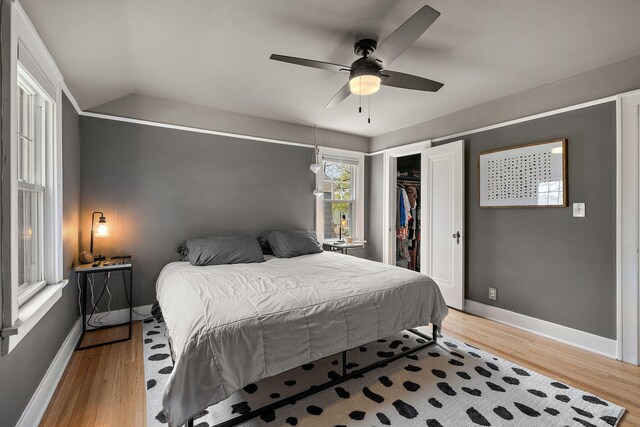 bedroom with baseboards, light wood finished floors, and ceiling fan