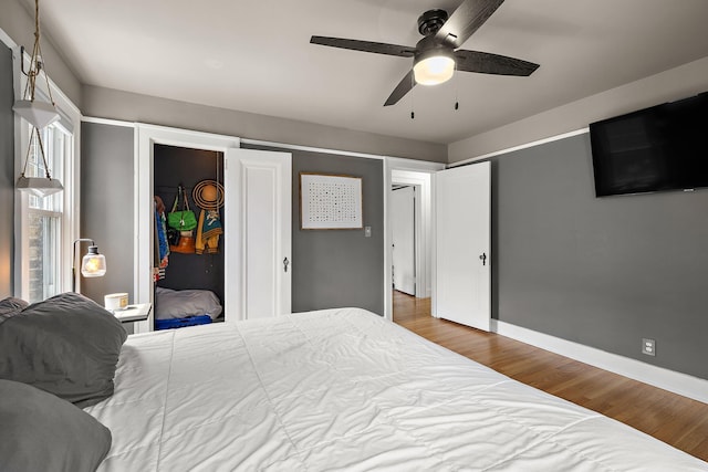 bedroom featuring baseboards, ceiling fan, and wood finished floors
