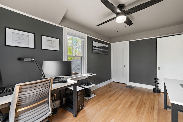 office featuring light wood-type flooring, a ceiling fan, and baseboards