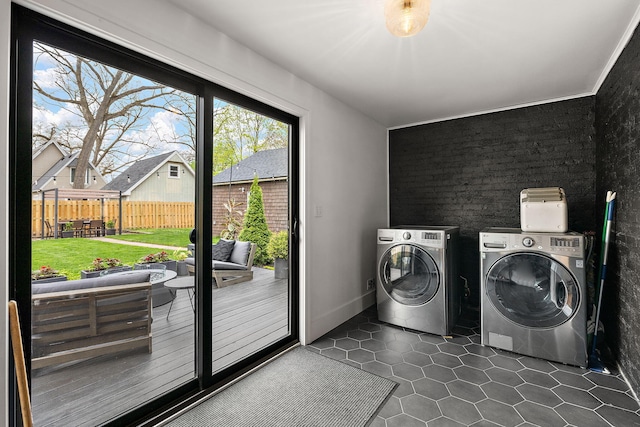 clothes washing area with laundry area, dark tile patterned flooring, and washing machine and clothes dryer