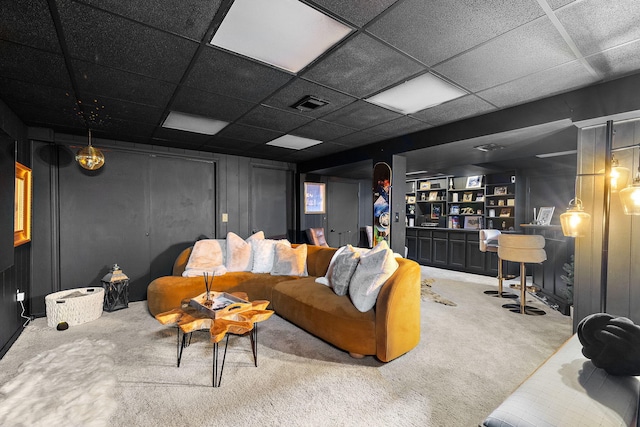 carpeted living room featuring visible vents and a paneled ceiling
