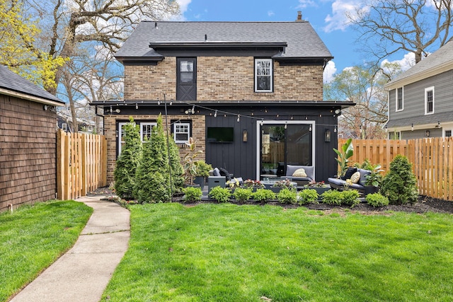 back of property with a lawn, an outdoor living space, fence, and brick siding
