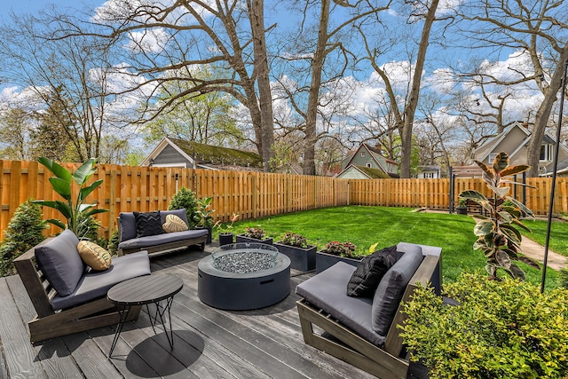 deck with a lawn, a fenced backyard, and an outdoor living space with a fire pit