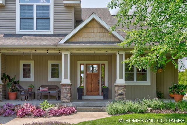 9145 Winterberry Dr, West Olive, MI 49460 - doorway to property featuring a porch, a shingled roof, and stone siding