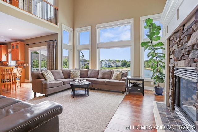 9145 Winterberry Dr, West Olive, MI 49460 - living area with a stone fireplace, a towering ceiling, wood-type flooring, and recessed lighting