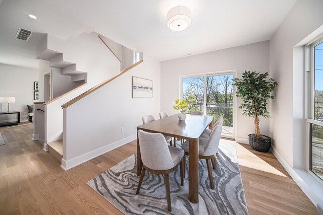 205 Sunset Rd, Ann Arbor, MI 48103 - dining area with light wood-type flooring, stairs, baseboards, and visible vents