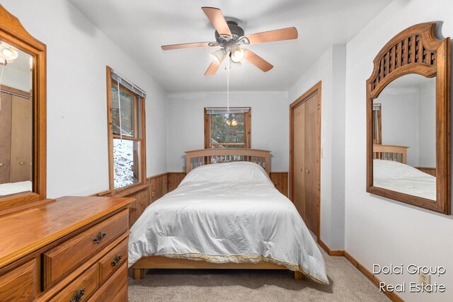 4600 S Teal Ln, Newaygo, MI 49337 - carpeted bedroom with a ceiling fan, wood walls, a wainscoted wall, and a closet