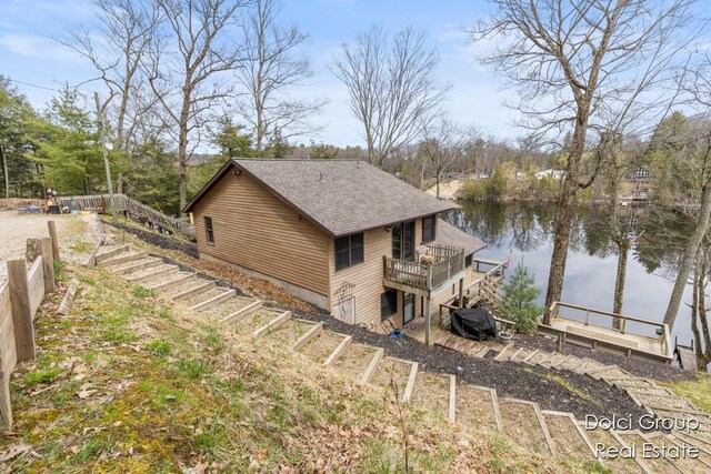 4600 S Teal Ln, Newaygo, MI 49337 - view of home's exterior featuring a shingled roof, a water view, and stairway