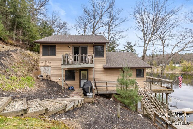 4600 S Teal Ln, Newaygo, MI 49337 - rear view of house with a shingled roof, stairway, a balcony, and a deck with water view