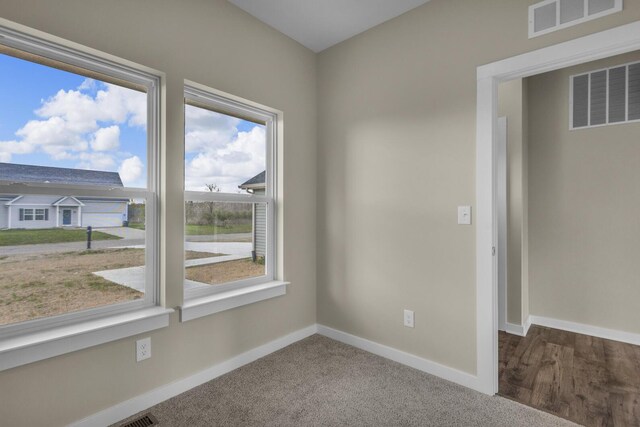 carpeted spare room with baseboards and visible vents