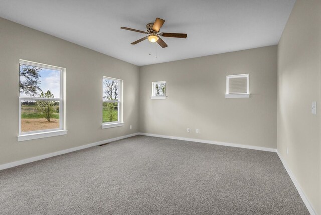 spare room with baseboards, carpet flooring, a ceiling fan, and visible vents