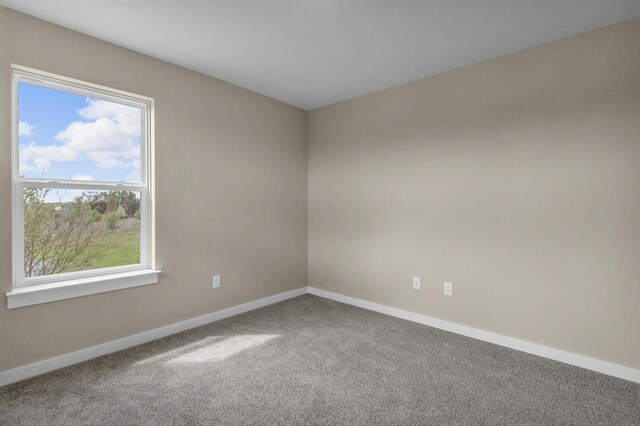 empty room featuring baseboards and carpet flooring