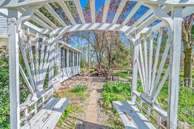 view of yard featuring a pergola and a sunroom
