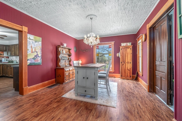dining area featuring crown molding, baseboards, an inviting chandelier, and dark wood-style floors